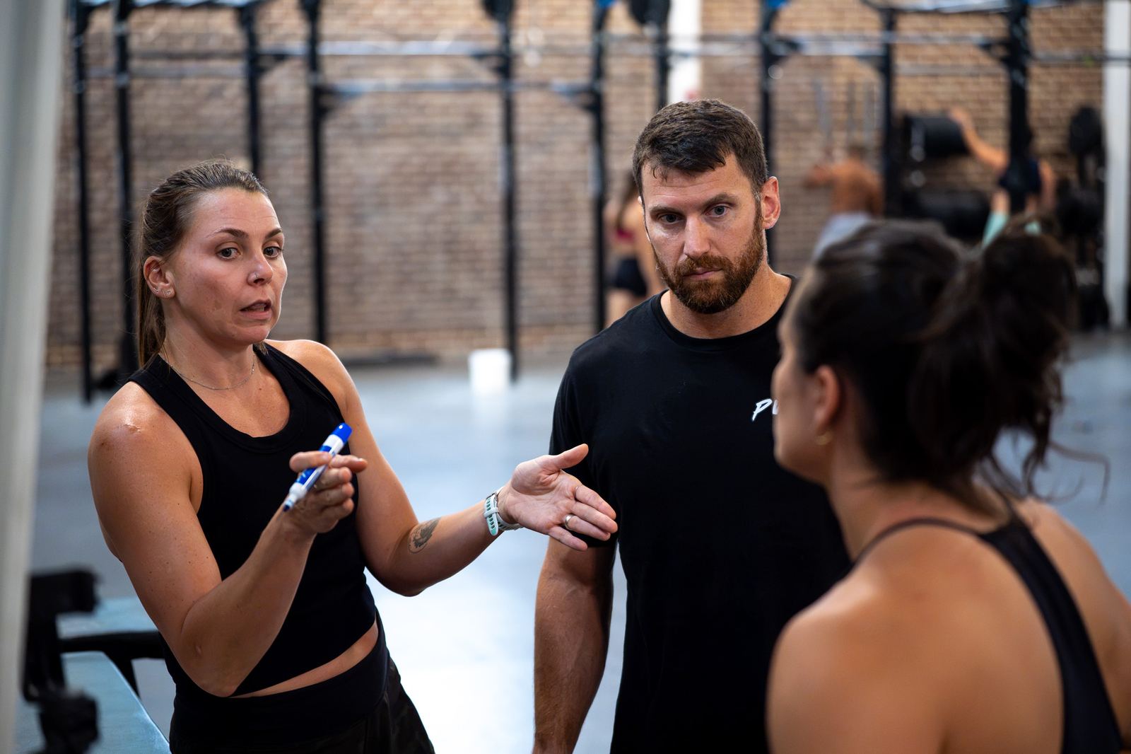 Haley Ruth coaching two athletes in a gym